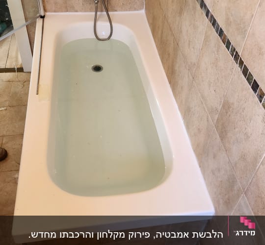 אמבטיה עם חיפוי אריחים חומים וברז כסוף